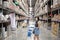 An asian woman doing shopping  and walking with her cart in cargo or warehouse.