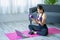 Asian woman doing shoulder stretching yoga at home in living room, fitness fit yoga for good health.