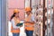 asian woman Engineer with note clipboard and asian man Supervisor in Hard Hats and Safety Vests Stand in Container Terminal.