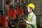 Asian woman engineering manager in safety hard hat and reflective cloth is inspecting inside the factory using digital tablet