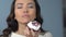 Asian woman enjoying taste of tasty sweet cupcake with whipped cream and fruit