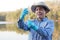 Asian woman environment researcher holds tube of sample water to inspect from the lake.