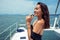 asian woman in evening black dress drinking champagne on the deck of a yachts