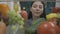 An Asian woman examines a refrigerator filled with healthy products. Satisfied woman nods her head, standing by the open