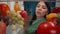 An Asian woman examines a refrigerator filled with healthy products: vegetables, fruits, berries. Satisfied woman nods