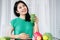 Asian woman experiencing delight and vitality relishes a refreshing blend of green fruits and vegetable juice