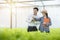 Asian woman farmer hold document files point pen to green lettuce for asian man scientist look come check quality of green