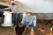 Asian woman feeding domestic chickens with corn in henhouse