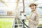 Asian woman finger press on temperature control machine in greenhouse hydroponic farm,Small business entrepreneur and organic