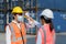 Asian woman foreman scanning fever temperature with digital thermometer to her staff worker wearing hygiene face mask protect from