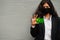 Asian woman at formal wear and black protect face mask hold Cocos Keeling Islands flag at hand against gray background.