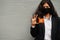 Asian woman at formal wear and black protect face mask hold Northern Territory flag at hand against gray background. Coronavirus