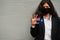 Asian woman at formal wear and black protect face mask hold Western Australia flag at hand against gray background. Coronavirus