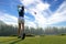 Asian woman golf player doing golf swing tee off on the green evening time in the blue sky background. She presumably does exerci