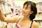 Asian woman happy to choose some book on bookshelf