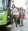 asian woman with headphones and bag smiling to the camera when stepped into the bus