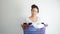 Asian woman holding basket of used clothes for washing. boring face. Concept of housework.