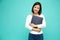 Asian woman holding documents files smile and standing on green background