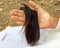 Asian woman, holding her long hair, is brown hair on the hand, that has hair loss problem