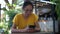 Asian woman  holding smartphone sitting outdoors cafe. Portrait of young woman typing smartphone at coffee break.