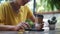 Asian woman  holding smartphone sitting outdoors cafe. Portrait of young woman typing smartphone at coffee break.