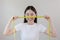 Asian woman holding a tape measure yellow around her waist. female happy smiling with tape measure put on face look at camera