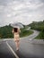 Asian woman holding umbrella on extremely curved road in mountain. Nan, Thailand. sky road on hill.