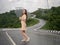 Asian woman holding umbrella on extremely curved road in mountain. Nan, Thailand. sky road on hill.