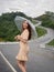 Asian woman holding umbrella on extremely curved road in mountain. Nan, Thailand. sky road on hill.