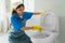 Asian woman housewife scrubbing and cleaning the toilet bowl in the bathroom at home