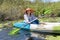 Asian woman kayaking on the river to see nature during the holidays