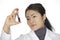 Asian woman laboratory technician examining a tube of blood