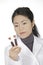 Asian woman laboratory technician examining a tube of blood