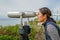 Asian woman looking in the binocular telescope on the tip of the Point Loma Peninsula in San Diego