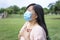 Asian woman in mask and  feels unhealthy put hand where is lungs, suffering from repeated coughing and breath difficulties