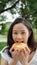 Asian woman mature adult eating bread carbohydrates
