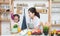 Asian woman mother and daughter play together in kitchen,mom hold tablet for teach little girl how to cook in semester break,
