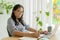 Asian woman noting down important information working at home, Asia businesswomen using computer laptop at home office, Side view