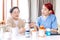 Asian woman nurse holding a medicine bottle and telling information to Asian senior woman before administering medication.