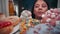 An Asian woman opens the doors of a refrigerator filled with desserts close up. A woman greedily examines desserts