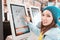 Asian woman orders food in the touch screen terminal with electronic menu in fastfood restaurant. Modern technology concept