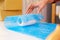 Asian woman packing a vase with air bubble wrap for a fragile product before sending in the parcel. Ready to send to a customer