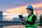 Asian woman petrochemical engineer working at night with digital tablet Inside oil and gas refinery plant industry factory at