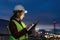 Asian woman petrochemical engineer working at night with digital tablet Inside oil and gas refinery plant industry factory at