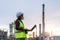 Asian woman petrochemical engineer working at night with notebook Inside oil and gas refinery plant industry factory at night for