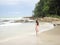 Asian woman in pink dress walking on beautiful beach at Samed, Thailand.