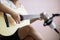 Asian woman play acoustic classic guitar for jazz and easy listening song and record with microphone select focus shallow depth of