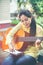 Asian woman playing acoustic guitar with bright sunlight. Vinta