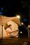Asian woman playing guitar in front of the tent in the campground at night