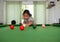 Asian woman playing snooker By aiming at his queue. Focus on the red ball
